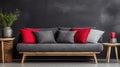 Log coffee table sits next to a rustic sofa with red and gray cushions against a dark plaster background. Royalty Free Stock Photo