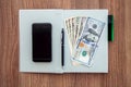 The daily log with denomination dollars on a wooden table. Royalty Free Stock Photo