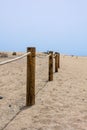 Log fence in a sandy shore on a sunny morning Royalty Free Stock Photo