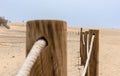 Log fence in a sandy shore on a sunny morning Royalty Free Stock Photo