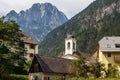 View on Central Parish Church and Buildings of Log pod Mangartom with Mount Rombon in the Background. Bovec, Slovenia, Europe