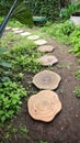 Log shape stepping stone pathway laying on the grass at garden or park Royalty Free Stock Photo