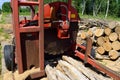 Log Slasher with Freshly Cut and Piled Wood Royalty Free Stock Photo