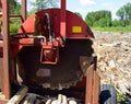 Log Slasher Saw with Tops and Limbs in Background