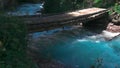 Wooden bridge across stormy mountain river