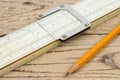 Logarithmic ruler, pencil on a wooden table. Stationery for engineers and students Royalty Free Stock Photo
