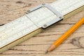 Logarithmic ruler, pencil on a wooden table. Stationery for engineers and students