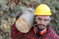 Logger holding heavy trunk in the forest