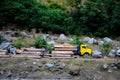 Loggers loading tree trunks onto yellow truck on mountainside Kaghan Pakistan Royalty Free Stock Photo