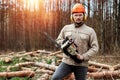 Logging, Worker in a protective suit with a chainsaw. Cutting down trees, forest destruction. The concept of industrial Royalty Free Stock Photo