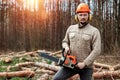 Logging, Worker in a protective suit with a chainsaw. Cutting down trees, forest destruction. The concept of industrial Royalty Free Stock Photo