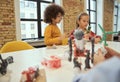 Logical analysis. Cute little boy and girl making robots during STEM class Royalty Free Stock Photo