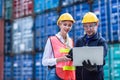 Logistic worker man and woman working team with online wireless laptop control loading containers at port cargo to trucks for
