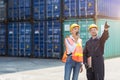 Logistic worker man and woman working team with radio control loading containers at port cargo to trucks for export and import