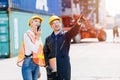 Logistic worker man and woman working team with radio control loading containers at port cargo to trucks for export and import