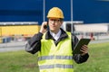 Logistician with phone and digital tablet on a background of logistic center.