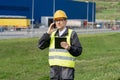 Logistician with phone and digital tablet on a background of logistic center.