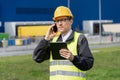 Logistician with phone and digital tablet on a background of logistic center.