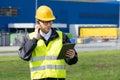 Logistician with phone and digital tablet on a background of logistic center