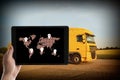 Logistics. Man using tablet with world map on screen against truck Royalty Free Stock Photo