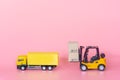 Logistics, and delivery service - Cargo truck, Forklift and paper cartons or parcel with a shopping cart logo on Pink background. Royalty Free Stock Photo