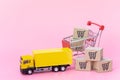 Logistics, and delivery service - Cargo truck, Red shopping cart and paper cartons or parcel with a shopping cart logo on Pink Royalty Free Stock Photo