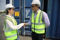 Logistics engineer control at the port, loading containers for trucks export and importing logistic concept.