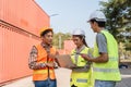 Logistics engineering team collaborating on a laptop while discussing project objectives at a construction site