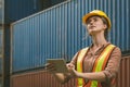 The logistics female staff is standing in front of colorful containers at habour warehouse, Supply chain and logistics concept Royalty Free Stock Photo