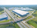 Logistics park with warehouse. Semi-trailers trucks standing on car parking and waiting for loading and unloading goods at ramps.