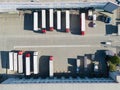 Logistics park with warehouse. Semi-trailers trucks standing on car parking and waiting for loading and unloading goods at ramps. Royalty Free Stock Photo