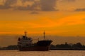 Logistics and transportation of International Container Cargo ship in the ocean at sunset,and silhouette of big boat Royalty Free Stock Photo