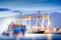 Logistics and transportation of international container cargo ship with ports crane bridge in harbor at dusk for logistics import Royalty Free Stock Photo
