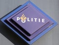 Logo of the dutch police force named Politie in a rectangle in blue on station in the Netherlands