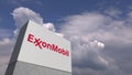 Logo of EXXON MOBIL on a stand against cloudy sky, editorial 3D rendering