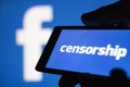 Logo of the Facebook blurred on background. The concept of censorship on popular social network Facebook. Shallow DOF