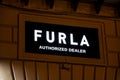 The logo of the Furla company above the store which sells bags and leather good. The image was taken at night