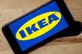 Logo of Ikea on iPhone 11 screen on a wooden bench. Royalty Free Stock Photo
