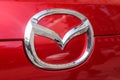 Logo of the manufacturer car company Mazda on a red vehicle's front