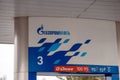 The logo and name of the Gazpromneft corporation, in Russian, and the designation of gasoline brands above the fuel pump under the