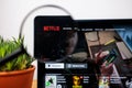 Logo of Netflix on a laptop desktop under a magnifying glass