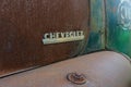 The logo of pickup truck Chevrolet on the rusty surface of the hood. Royalty Free Stock Photo