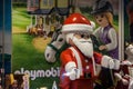 Logo of Playmobil in front of a Giant Christmas Santa Claus Figurine on display in front of a shop. Playmobil is German toy brand