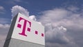 Logo of T TELEKOM on a stand against cloudy sky, editorial 3D rendering