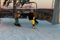 Logoisk. Belarus. 01.03.2023. Four teenage snowboarders ski down the slope of a snow-covered