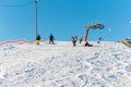 Logoisk. Belarus. 01.06.2023. A group of children snowboarders with a coach descend from a snow-covered mountain