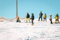 Logoisk. Belarus. 01.10.2023. A group of children snowboarders descend from the slope of a snow-covered mountain