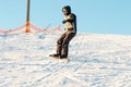 Logoisk. Belarus. 01.13.2023. The guy-snowboarder descends from the slope of a snow-covered mountain