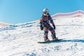 Logoisk. Belarus. 01.04.2023. A teenage snowboarder descends the slope of a snow-covered mountain in special equipment.