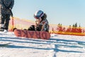 Logoisk. Belarus. 01.15.2023. A teenage snowboarder is preparing to descend a snow-covered mountain in special equipment. Winter